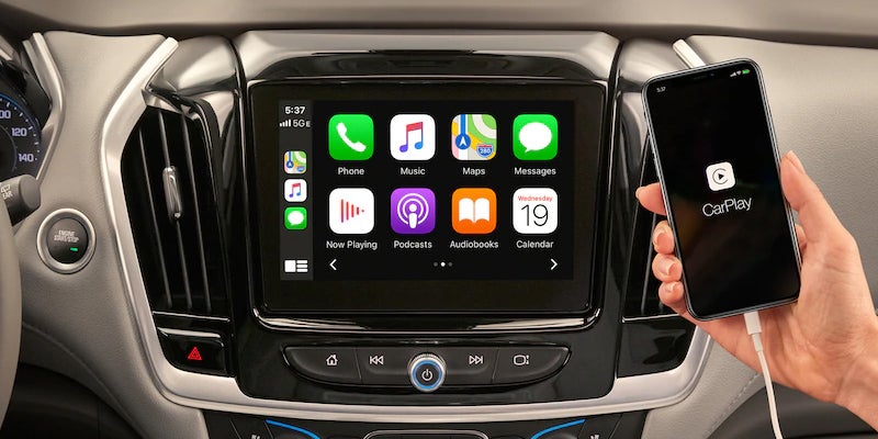 Interior of a used Chevy Traverse showing three-row seating and infotainment touchscreen