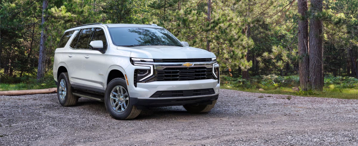 Image of a white Chevrolet Tahoe parked on a rocky path in a forest