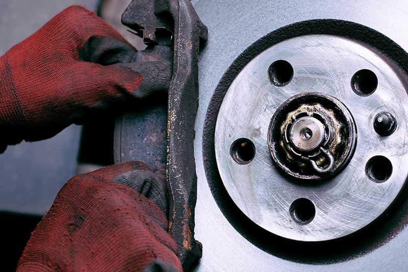 Factory-trained technician changing brake pads